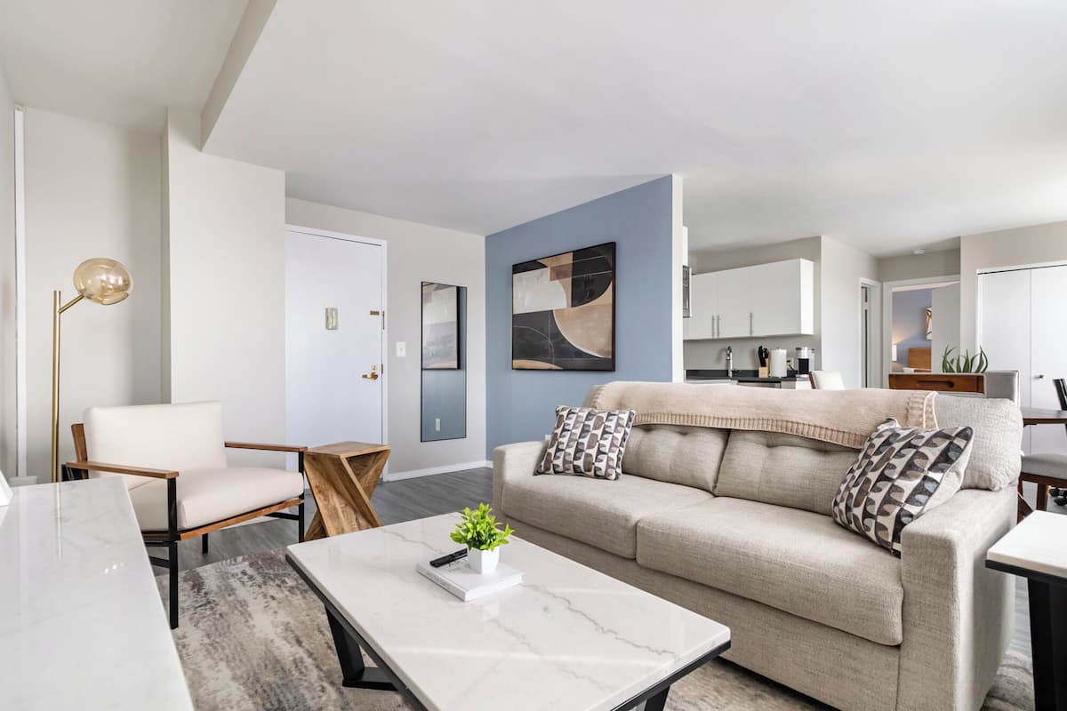 Ein modernes Wohnzimmer mit Sofa, Couchtisch und Stehlampe.
