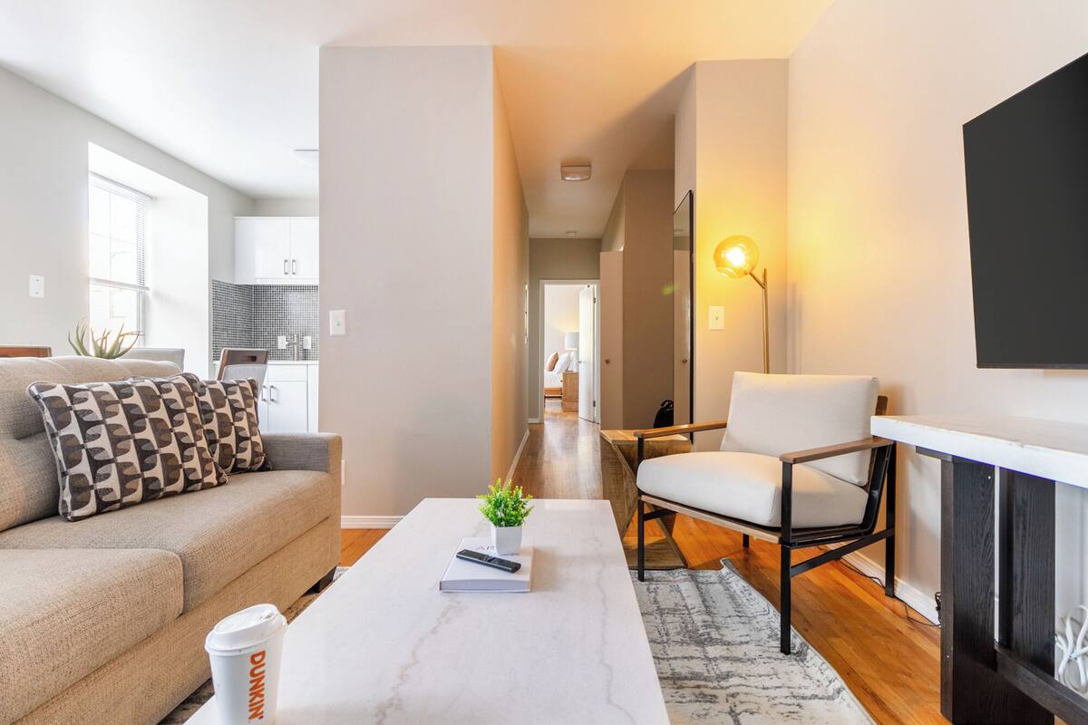 Ein modernes Wohnzimmer mit Sofa, Sessel, Couchtisch und Kamin.