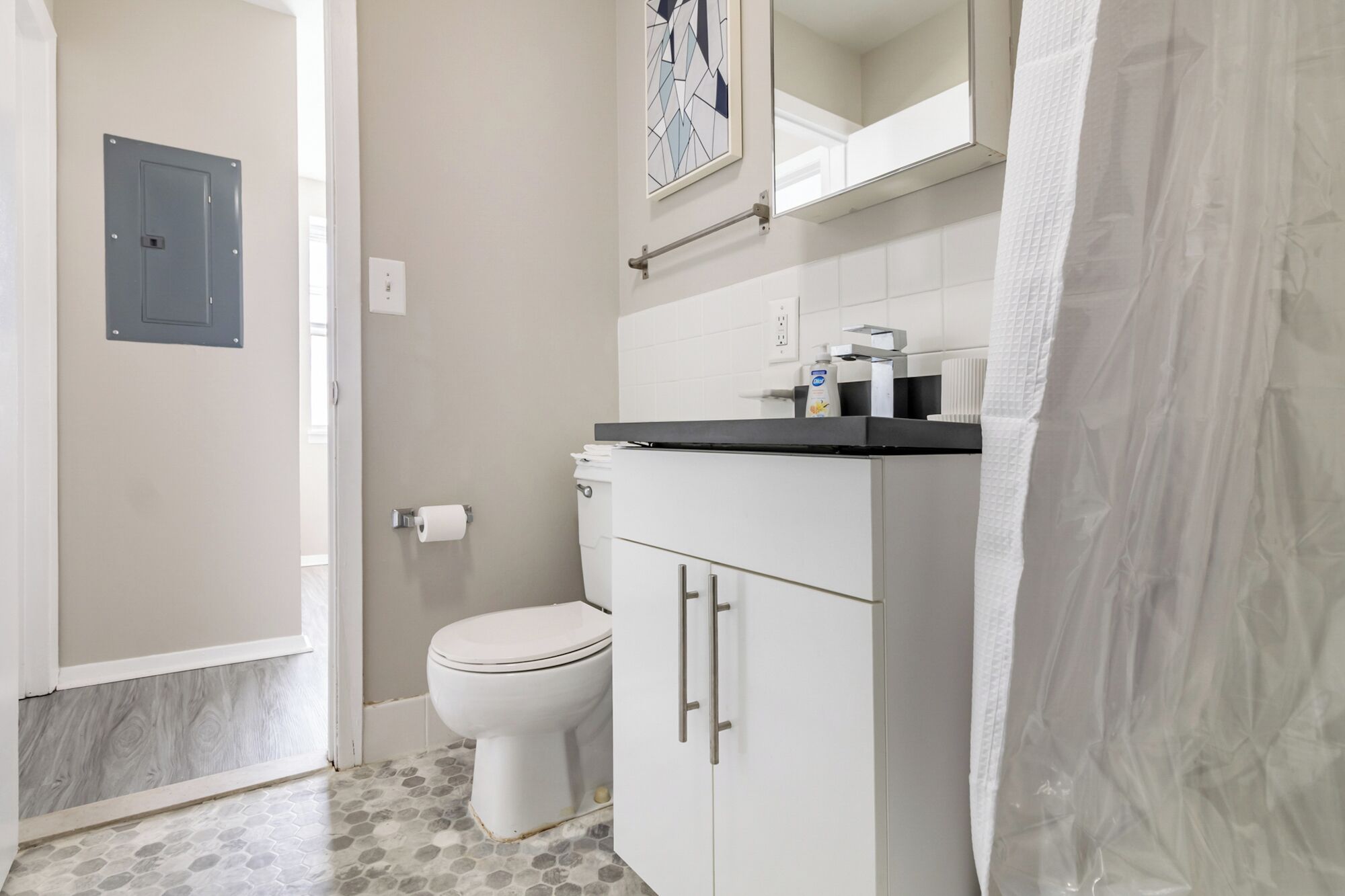 Een badkamer met toilet, wastafel en douchegordijn.