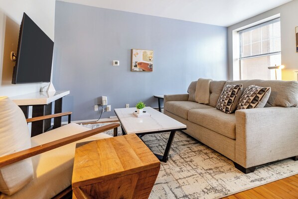 A living room with a sofa, coffee table, and TV. - Landing Furnished Apartment Near Yale University (New Haven)