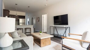A modern living room with a sofa, coffee table, and TV. - Landing Furnished Apartments - Bloomingdale (Bloomingdale)