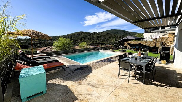 A rooftop pool area with lounge chairs, a dining table, and a view of a mountainous landscape. - Villa 4 bedrooms heated pool Sainte Maxime (Sainte-Maxime)