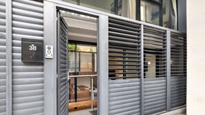 A modern building entrance with a metal gate, a mailbox, and a visible door. - Modern Carlton Living Minutes to CBD (Melbourne)