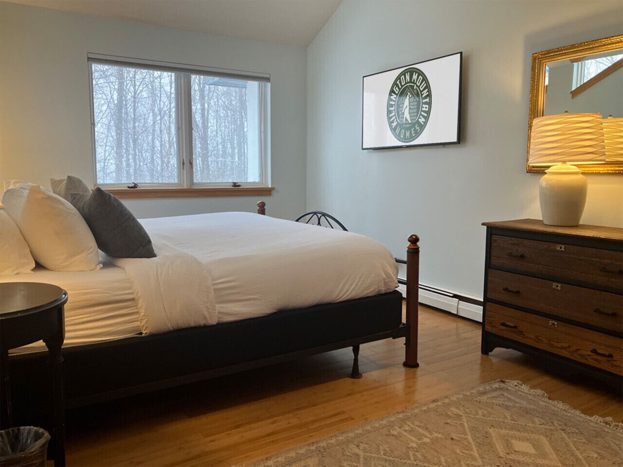 Un dormitorio con cama, cómoda, ventana y un cuadro en la pared.