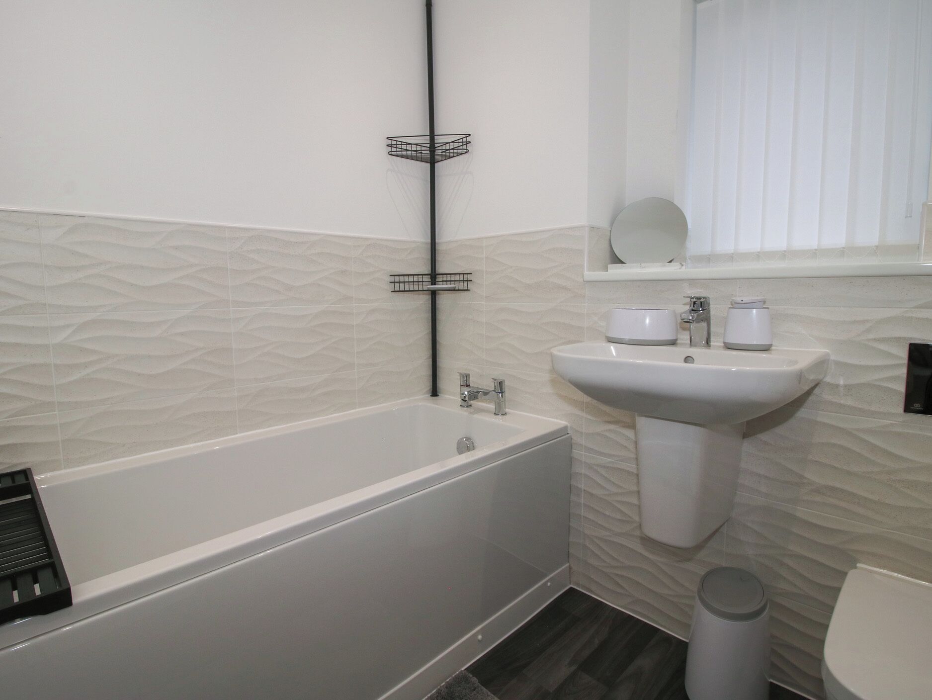 A bathroom with a bathtub, a sink, and a toilet.