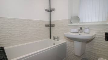 Ein Badezimmer mit Badewanne, Waschbecken und Toilette.