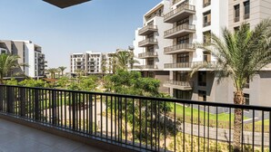 A modern residential building with multiple balconies, surrounded by greenery and palm trees. - Designer 3BR Serviced Apart At Cairo Festival City (Cairo Governorate)