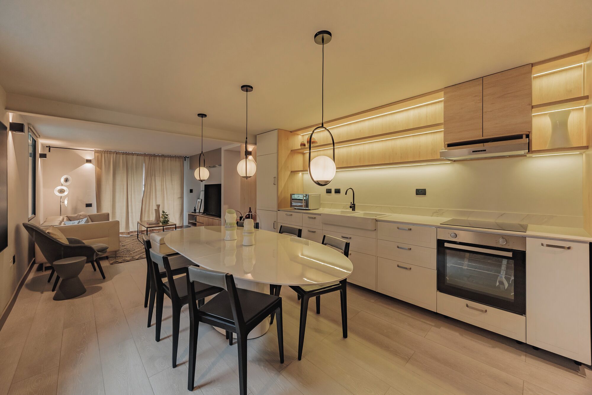 A modern kitchen with a central island, built-in appliances, and pendant lighting.