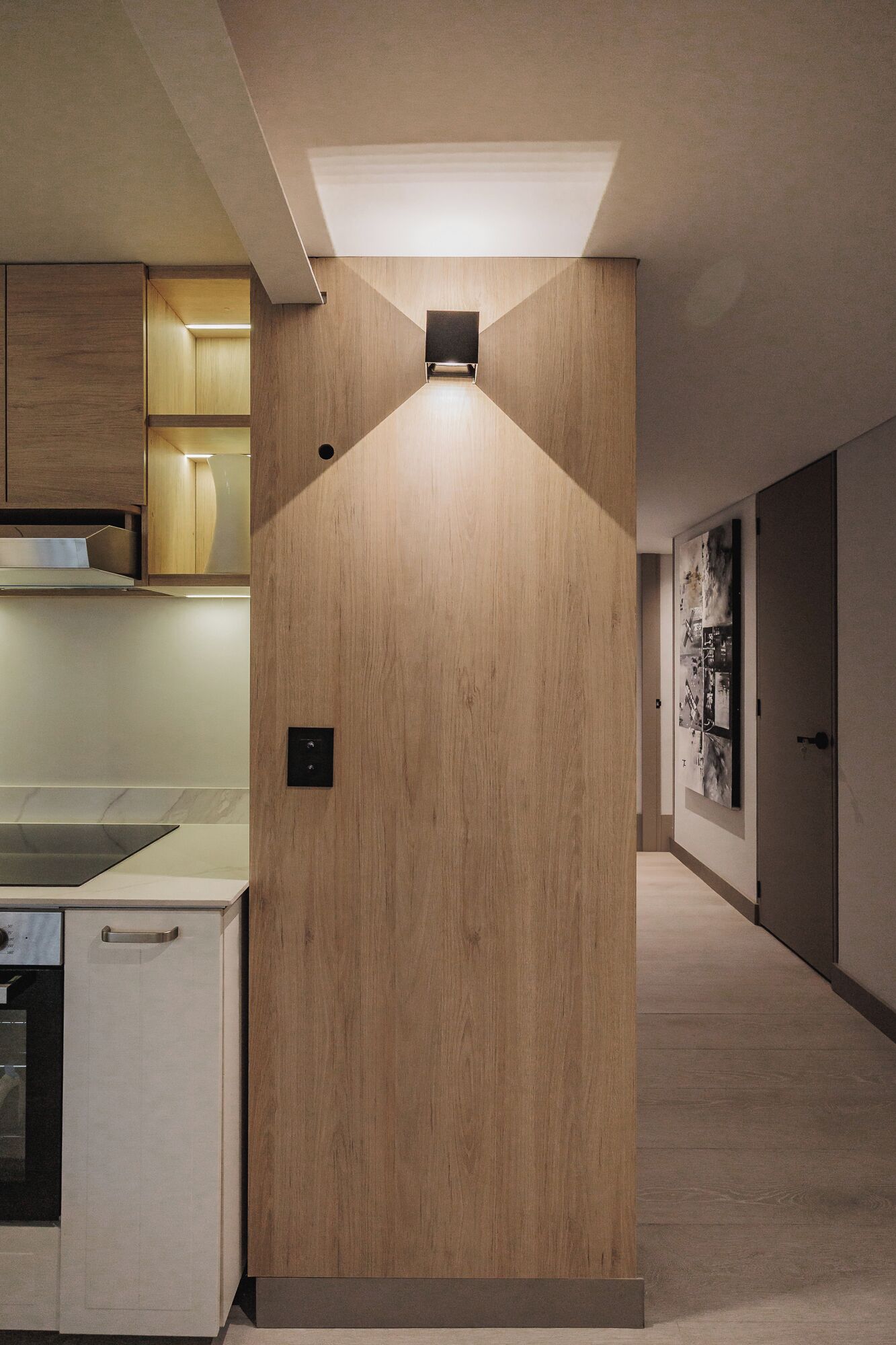 A modern kitchen with wooden cabinetry, a built-in oven, and a countertop.