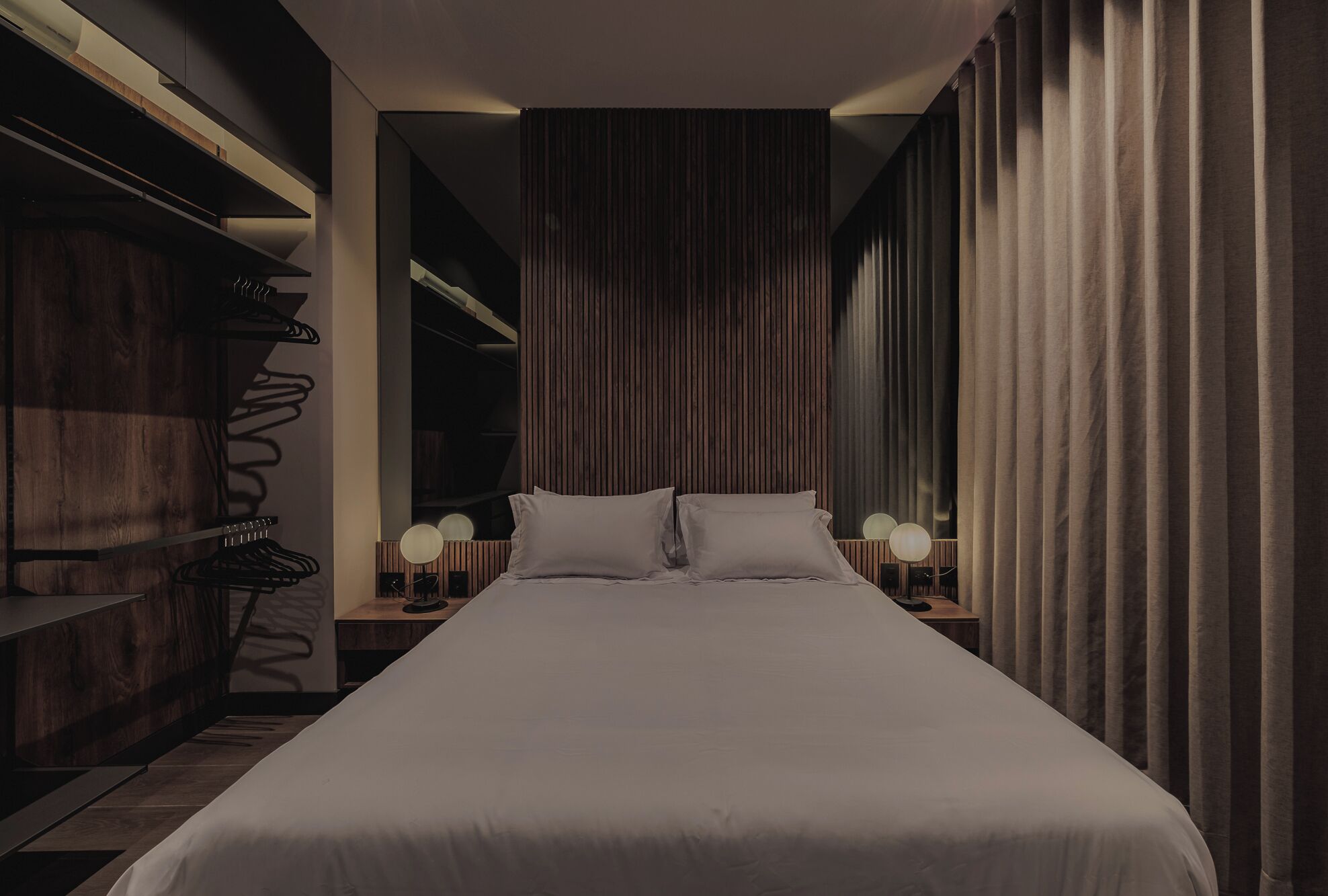 Una camera da letto moderna con un letto grande, un'armadiatura in legno e uno specchio.