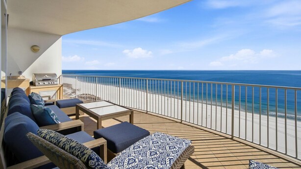 A balcony with a view of the ocean, a grill, and seating with cushions. - Turquoise D1005 (Orange Beach)