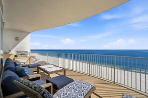A balcony with a view of the ocean, a grill, and seating with cushions. - Turquoise D1005 (Orange Beach)