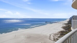 A beach view from a balcony with a pier extending into the ocean. - Turquoise D1005 (Orange Beach)