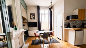 A modern kitchen with a dining area, wooden flooring, and a view of the outdoors. - Comfortable studio in the heart of Le Touquet (Le Touquet-Paris-Plage)