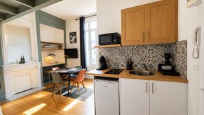 A modern kitchen with wooden cabinets, a microwave, and a dishwasher. - Comfortable studio in the heart of Le Touquet (Le Touquet-Paris-Plage)