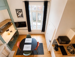 A compact kitchen with a dining area, a TV, and a window with curtains. - Comfortable studio in the heart of Le Touquet (Le Touquet-Paris-Plage)