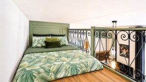 A bedroom with a bed, green headboard, and a balcony with a wrought iron railing. - Comfortable studio in the heart of Le Touquet (Le Touquet-Paris-Plage)