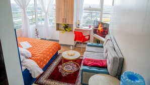 Una habitación de hotel moderna con una cama, un sofá, un escritorio y un televisor.