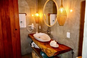 A bathroom with a wooden vanity, a white sink, and two wall-mounted mirrors. - Casa PreguiƧa (Corumbau)