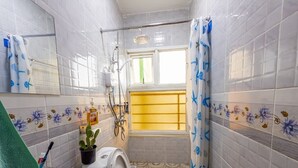 A bathroom with a toilet, bidet, and a shower area. - 6. Ash latte Suite at VillaromAfrica Staycations (Eldoret)