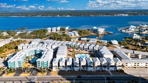 A coastal hotel with multiple-story buildings, a swimming pool, and a marina. - West Lagoon Cottages- Unit K (Gulf Shores)