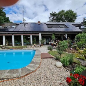 A modern house with a swimming pool, solar panels, and a garden. - Wohnen in der Galerie (Worpswede)