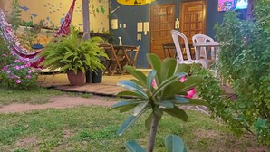 Eine Terrasse mit Holztisch und -stühlen, Kübelpflanzen und einer Hängematte.