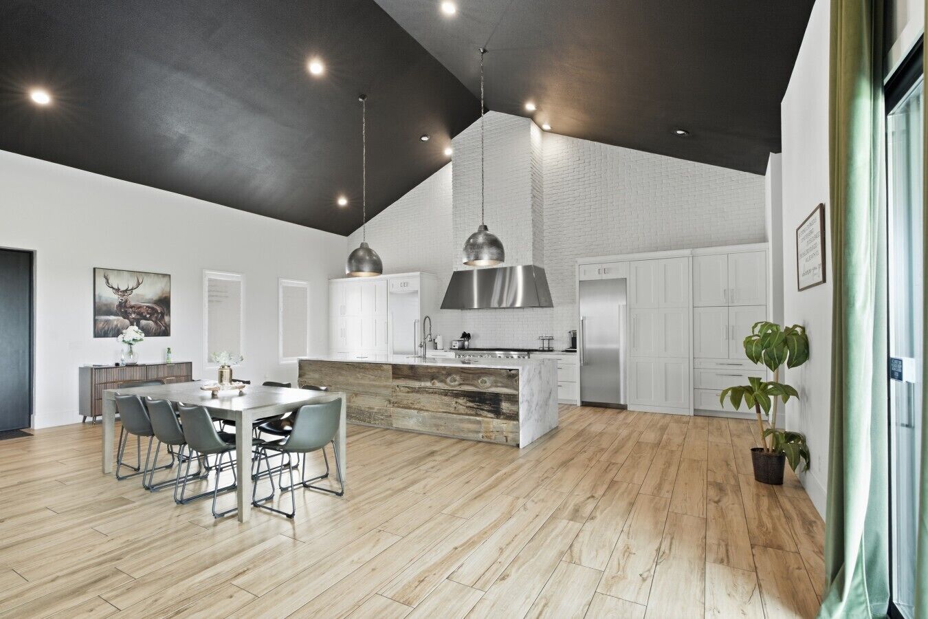 Una cocina moderna con armarios blancos, una isla central e iluminación colgante.