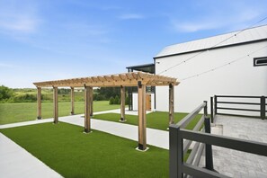 Una estructura de pérgola de madera con un cielo despejado al fondo.