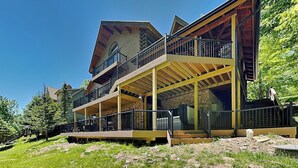 A multi-story building with balconies, wooden beams, and a stone facade. - Wisp Water Lodge (McHenry)