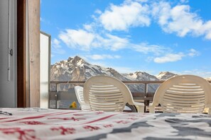 A balcony with a mountain view, featuring two white chairs and a table. - Christiania I R1 - 4 pers - near the slopes (Haute-Nendaz)