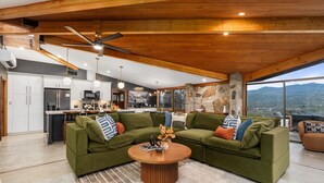 A modern living room with a sectional sofa, a round coffee table, and a view of the mountains. - Stunning views | Hot tub | Games | 5BR Sleeps 14 (Oakhurst)