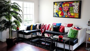 A living room with a sofa, coffee table, and a large potted plant. - Home located  10 minute from Hard Rock Stadium Home of the FIFA World Cup 2026  (Miramar)