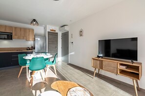 Ein moderner Wohnbereich mit Essplatz, Küche und Unterhaltungseinheit.