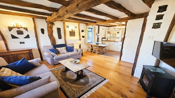 A cozy living room with a sofa, a coffee table, and a fireplace. - Honeycott | Sleeps 4 | Croyde Beach (Croyde)