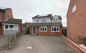 A residential area with a two-story house, a garage, and a paved driveway. - Charming 3 bedroom house in Chelmsford (Essex)
