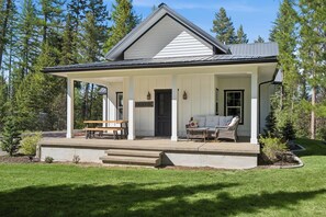 Ein Haus mit einer Veranda, einer Bank und einem Schild mit der Aufschrift 'RMHOUSE'.