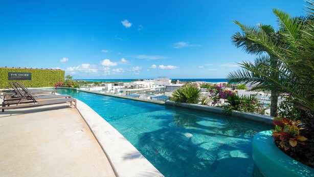 A swimming pool with lounge chairs and a view of the ocean. - 2 BR Condo Rooftop Ocean View - Sasha I (Playa del Carmen)