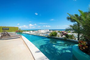 A swimming pool with lounge chairs and a view of the ocean. - 2 BR Condo Rooftop Ocean View - Sasha I (Playa del Carmen)