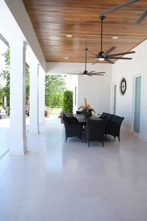 A covered patio with a dining table and chairs, ceiling fans, and a view of the outdoors. - Welcome to Casa Hibiscus, your private tropical escape in Miami! 4-bd, 4-baths (Miami)