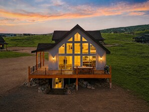Uma casa grande e moderna com uma varanda imponente, interior espaçoso e uma vista panorâmica da paisagem circundante.