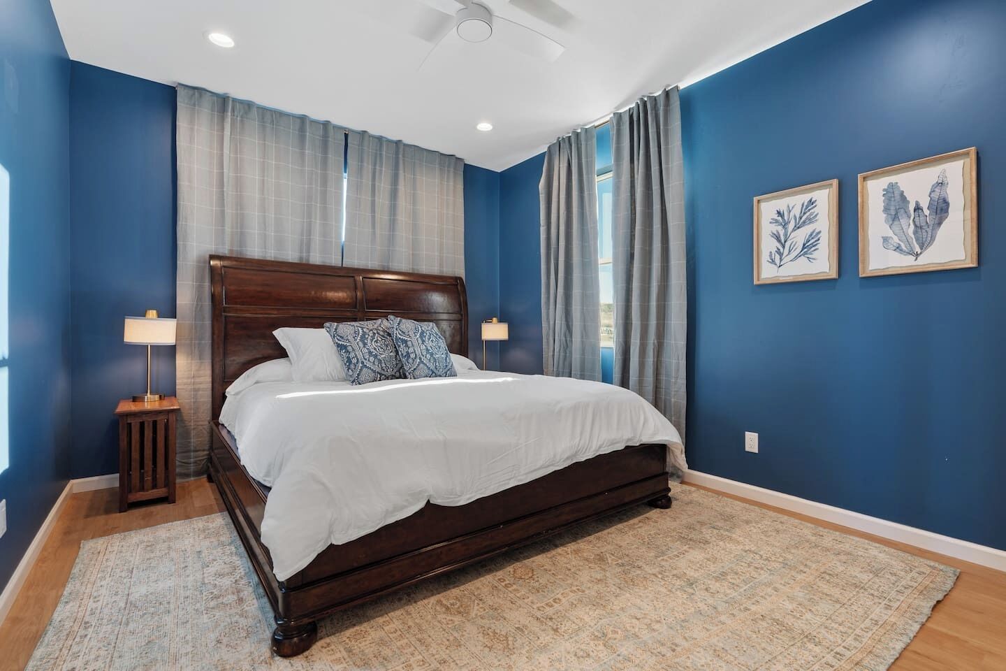 A bedroom with a dark wooden bed, white bedding, and two nightstands with lamps.