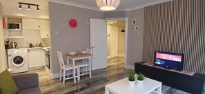 A compact living space with a kitchen, dining area, and a TV. - Modern Central 1BDR At St Stephen Green (Dublin 2)