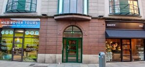 A building with a green door, a Wild Rover Tours sign, and a Davey store. - Modern Central 1BDR At St Stephen Green (Dublin 2)