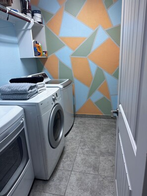 A laundry area with a washing machine, dryer, and neatly folded towels.