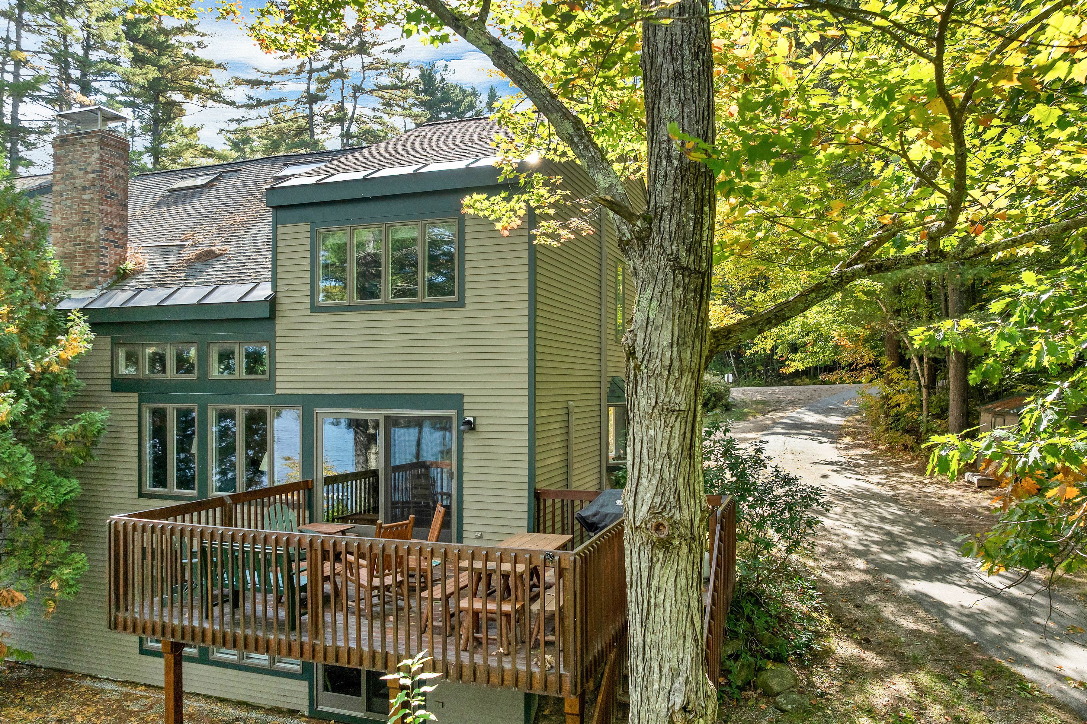 A two-story house with a deck and a chimney.