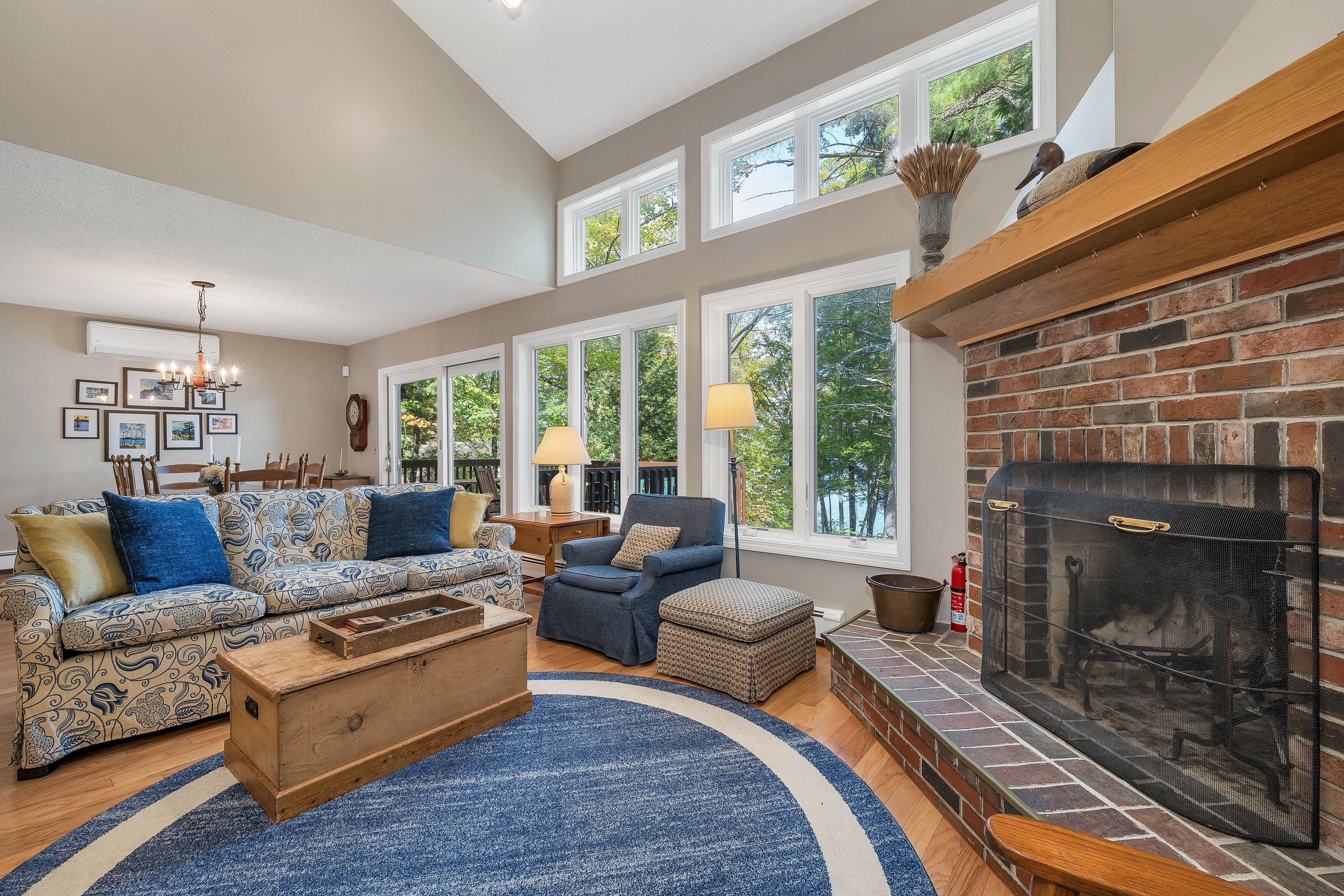 A spacious living room with a fireplace, large windows, and a variety of seating options.