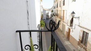 A narrow street with white buildings, a black metal railing, and greenery. - Apartment Sleeps 4 Alhama de Granada Town Centre (Alhama de Granada)