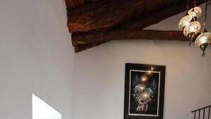 A staircase with a chair and a framed picture on the wall. - Apartment Sleeps 4 Alhama de Granada Town Centre (Alhama de Granada)