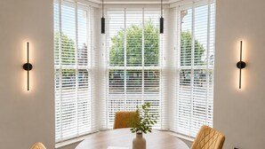 A dining area with a round table, four chairs, a vase with a plant, and a book. - East Parade Collection, 35 Nova House (North Yorkshire)
